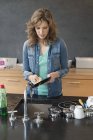 Женщина моет посуду на современной кухне — стоковое фото