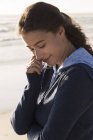 Charmante junge Frau im Kapuzenpulli steht am Strand — Stockfoto