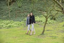 Frau mit Teenager-Tochter spaziert in Obstgarten — Stockfoto