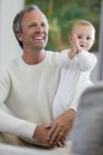 Happy father with cute baby daughter in living room — Stock Photo