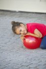 Портрет милої маленької дівчинки, що грає з м'ячем на вулиці — стокове фото