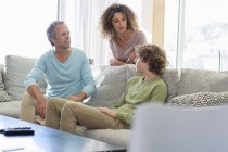 Family resting and talking in living room at home — Stock Photo