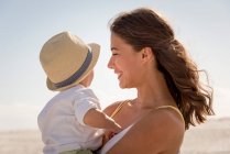 Щаслива мати зі своїм маленьким сином насолоджується на пляжі — стокове фото