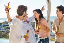 Grupo de amigos disfrutando de la cerveza al aire libre de vacaciones - foto de stock