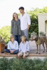 Ritratto di famiglia felice che si diverte sul cortile con cane — Foto stock