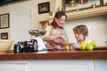 Nonna e bambino cucinare cibo in cucina — Foto stock