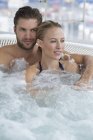 Portrait of relaxed laughing couple resting in hot tub — Stock Photo