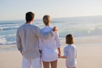 Family standing on the beach — Stock Photo