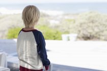Rear view of little boy standing outdoors — Stock Photo