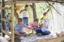 Children playing in tree house in summer garden — Stock Photo