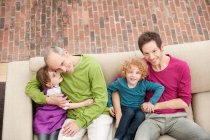 Famiglia seduta su un divano — Foto stock