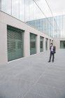 Geschäftsmann SMS auf Handy im Freien Bürogebäude — Stockfoto