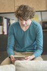 Хлопчик-підліток використовує цифровий планшет у вітальні — стокове фото