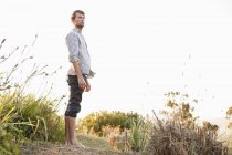 Mann steht in der Natur auf Wanderschaft und schaut weg — Stockfoto
