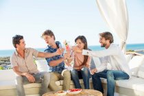 Group of friends toasting drinks outdoors on vacation — Stock Photo