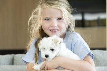 Портрет милой девочки, держащей щенка — стоковое фото