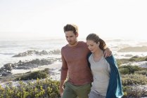 Entspanntes romantisches Paar spaziert gemeinsam an der Küste — Stockfoto