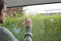 Closeup of man drawing architecture design on glass of window — Stock Photo