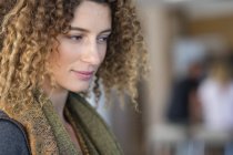 Portrait of thoughtful happy woman with curly hair — Stock Photo