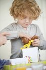Mignon petit garçon ouvrant cadeau de chocolat de Pâques — Photo de stock