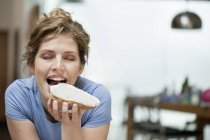 Porträt einer jungen Frau, die Toast mit Sahneaufstrich isst — Stockfoto