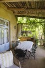 Table and chairs on veranda of countryside house in summer — Stock Photo
