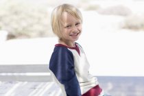 Портрет щасливого маленького хлопчика, який посміхається на відкритому повітрі на сонячному світлі — стокове фото