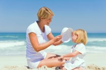Femme assise avec sa fille sur la plage — Photo de stock