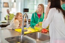 Girls with her mother in a kitchen — Stock Photo