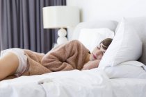 Young woman in comfy sweater sleeping on bed — Stock Photo