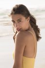 Retrato de sensual jovem mulher de pé na praia — Fotografia de Stock
