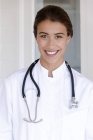 Portrait of happy female doctor standing and looking at camera — Stock Photo
