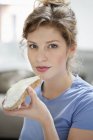 Porträt einer Frau, die Toast mit Sahneaufstrich isst — Stockfoto