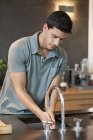 Mann wäscht sich in moderner Küche die Hände — Stockfoto