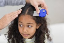 Mother using lice comb on daughter hair — Stock Photo