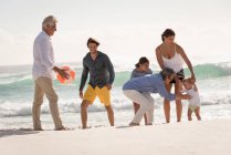 Счастливая семья из нескольких поколений наслаждается на пляже — стоковое фото