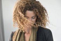 Close-up of woman with curly hair looking down — Stock Photo
