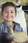 Ritratto di bambina sorridente con in braccio un modello di tacchino — Foto stock
