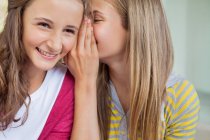 Close-up of two girls whispering in a school — Stock Photo