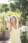Smiling mature woman taking selfie in summer garden — Stock Photo