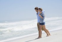 Pareja romántica caminando en la playa de arena juntos - foto de stock