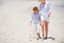 Жінка йде з сином на пляжі — стокове фото