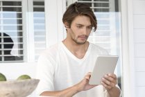 Junger Mann nutzt digitales Tablet auf Terrasse — Stockfoto