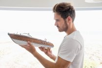 Молодий чоловік тримає модель човна — стокове фото