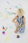 Милая маленькая девочка рисует на ладони — стоковое фото