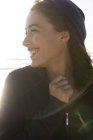 Nahaufnahme einer lachenden jungen Frau im Kapuzenpullover am Strand — Stockfoto