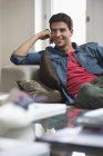Happy man reclining on couch and looking away — Stock Photo