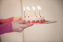 Primer plano de las manos femeninas sosteniendo pastel de cumpleaños - foto de stock