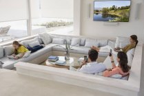 Familia multi-generación utilizando gadgets en la sala de estar - foto de stock