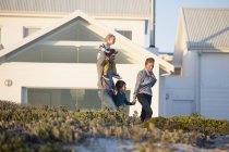 Glückliche Familie zu Fuß vor dem Haus in der Landschaft — Stockfoto